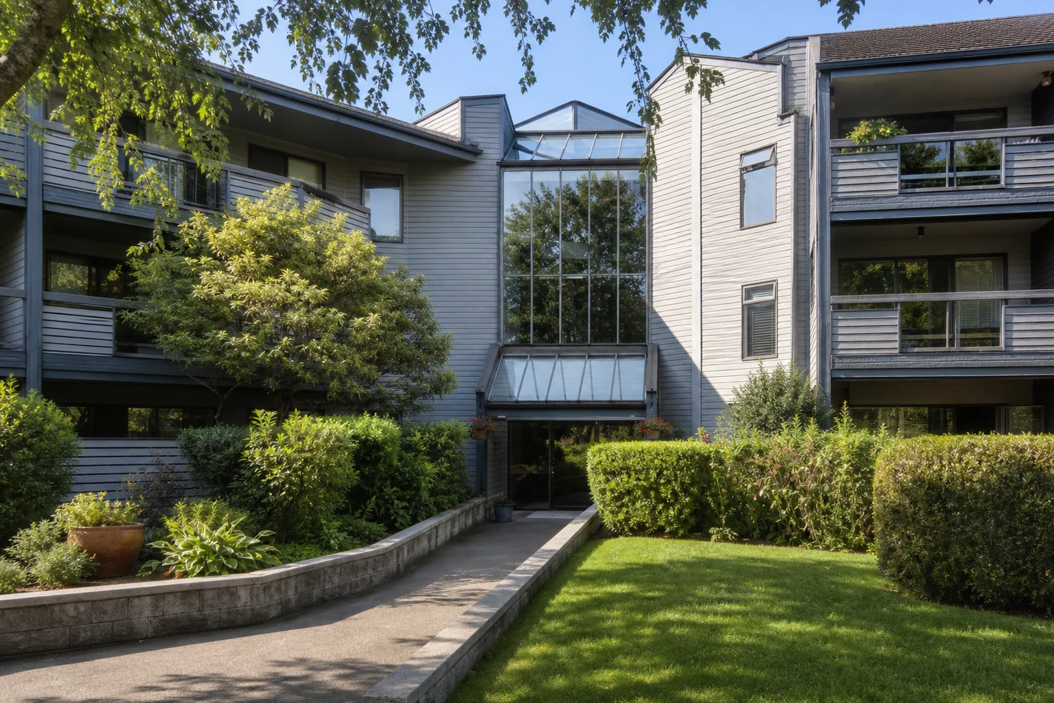 Promotional architectural view of Hambry Court's glazed atrium and landscaped entrance courtyard